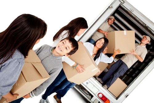 Professional team handling piano removals in Plumstead with protective wrapping