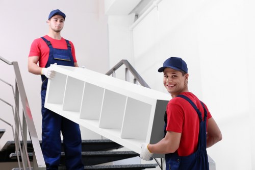Upright piano being carefully moved through a Plumstead home